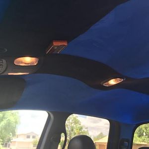Custom Suede headliner in blue with a black stripe down the center to offset the seats which are opposite of that. Visors upholstered in Black Suede.