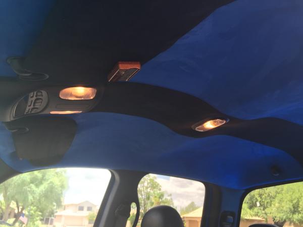 Custom Suede headliner in blue with a black stripe down the center to offset the seats which are opposite of that. Visors upholstered in Black Suede.